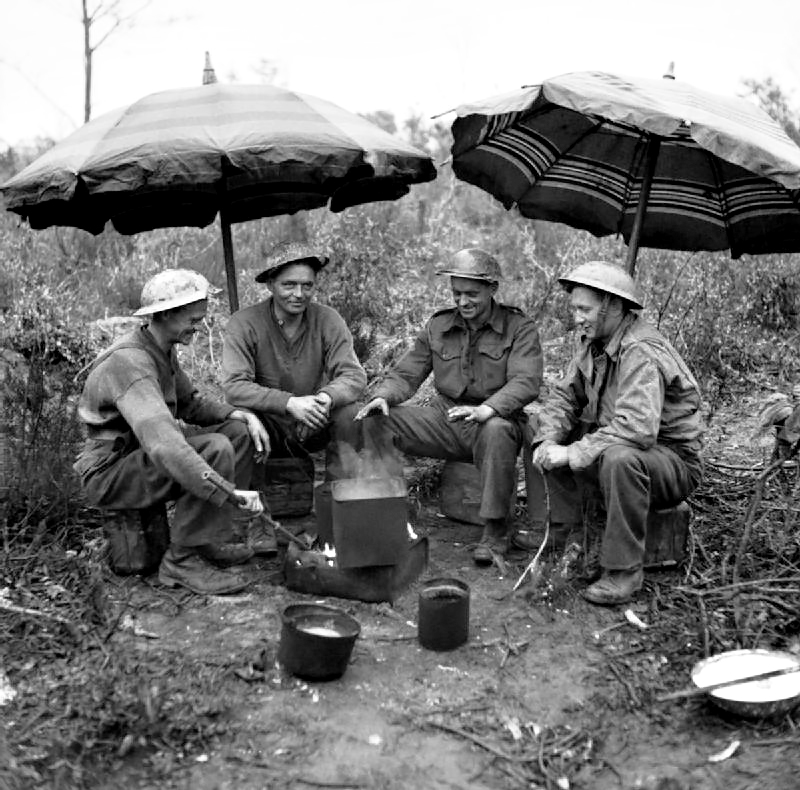 SSAFA's tweet image. Time for a brew? #OnThisDay in 1944, Gunners of 78th Field Regiment @rhqra make use of two sunshades from an Anzio café to keep the rain off while making tea. #WW2