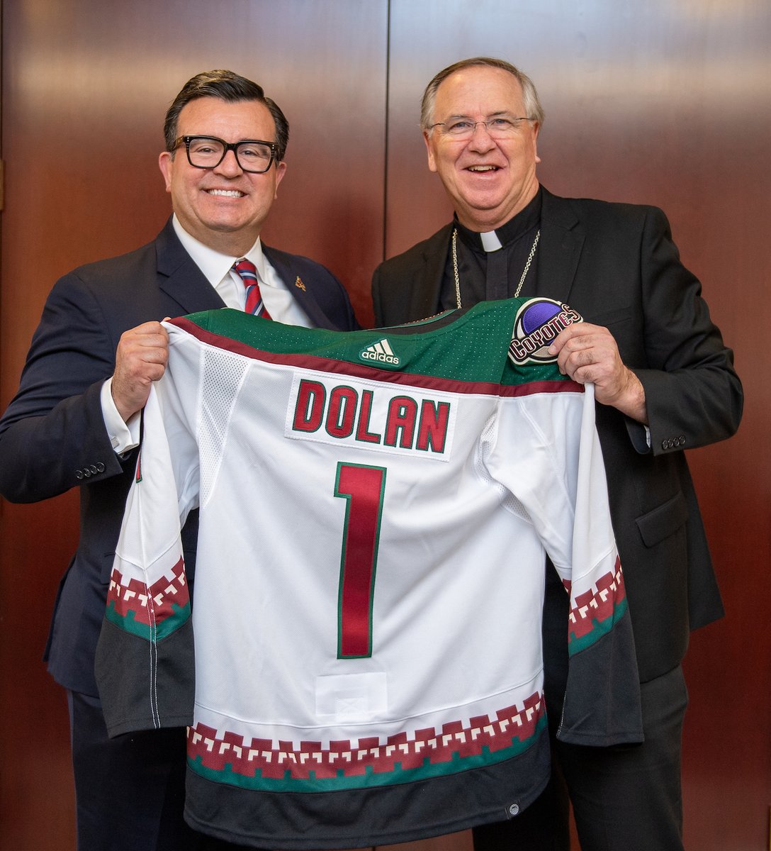 PhoenixDiocese's tweet photo. Bishop John Dolan was welcomed to the valley this week by @arizonacoyotes president and CEO, Xavier Gutierrez, with a personalized sweater from the team.
#DPHX #coyotes #nhl #arizonacoyotes #yotes https://t.co/fspITOk994