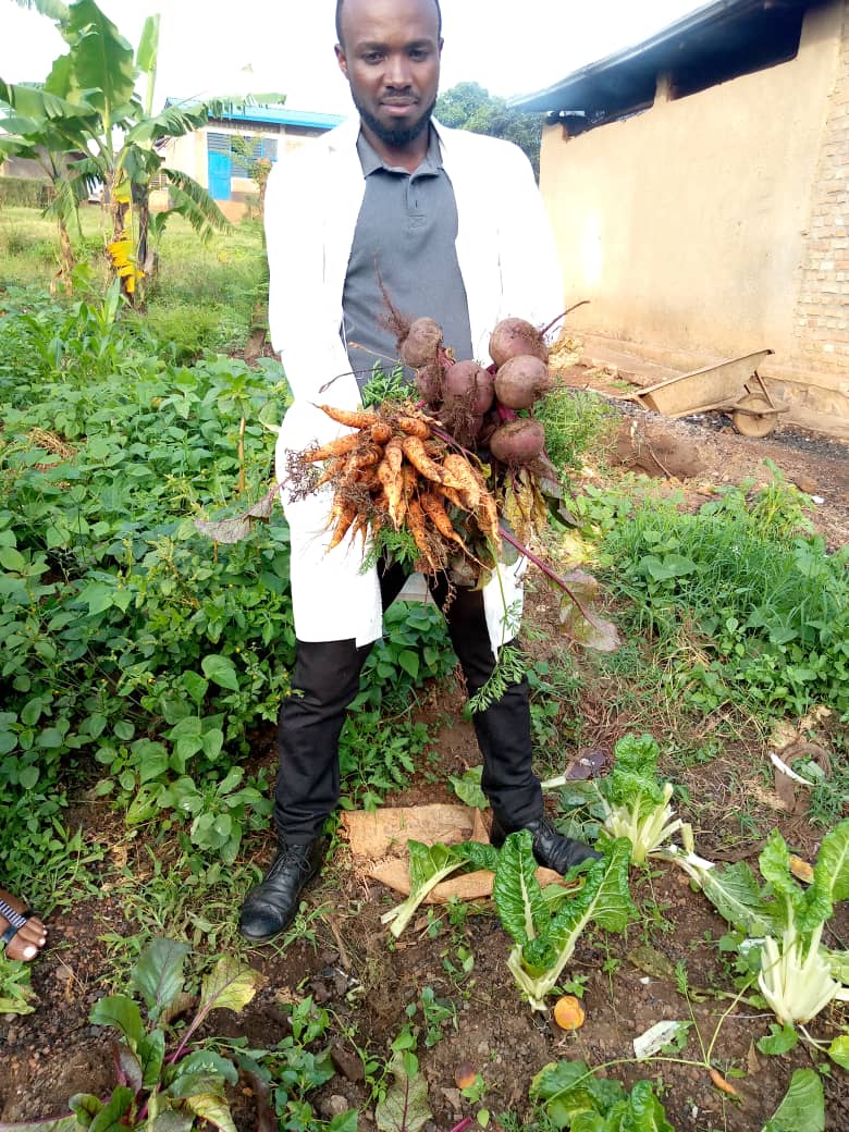 Just In: A teacher in Ruramira Sec. School in @RuramiraSector of @KayonzaDistrict displays a sample harvest of beetroot & carrots from the school garden under the school-gardening project @36Tesf & @GER_Global & @Uni_Rwanda. @EKGasana @BristolUni @BoscoNyemazi @TransformingESF