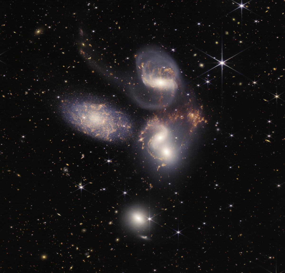 NASAExoplanets's tweet photo. Serene galaxies floating in space? Nope! A shockwave multiple times the size of the Milky Way is violently stirring the 'intergalactic medium' of Stephen's Quintet. Check out @NASAWebb science in this roundup: Exoplanet firsts, galaxy discoveries &amp; more. https://t.co/j66Mx2MQ01 https://t.co/4IEuuzg12J