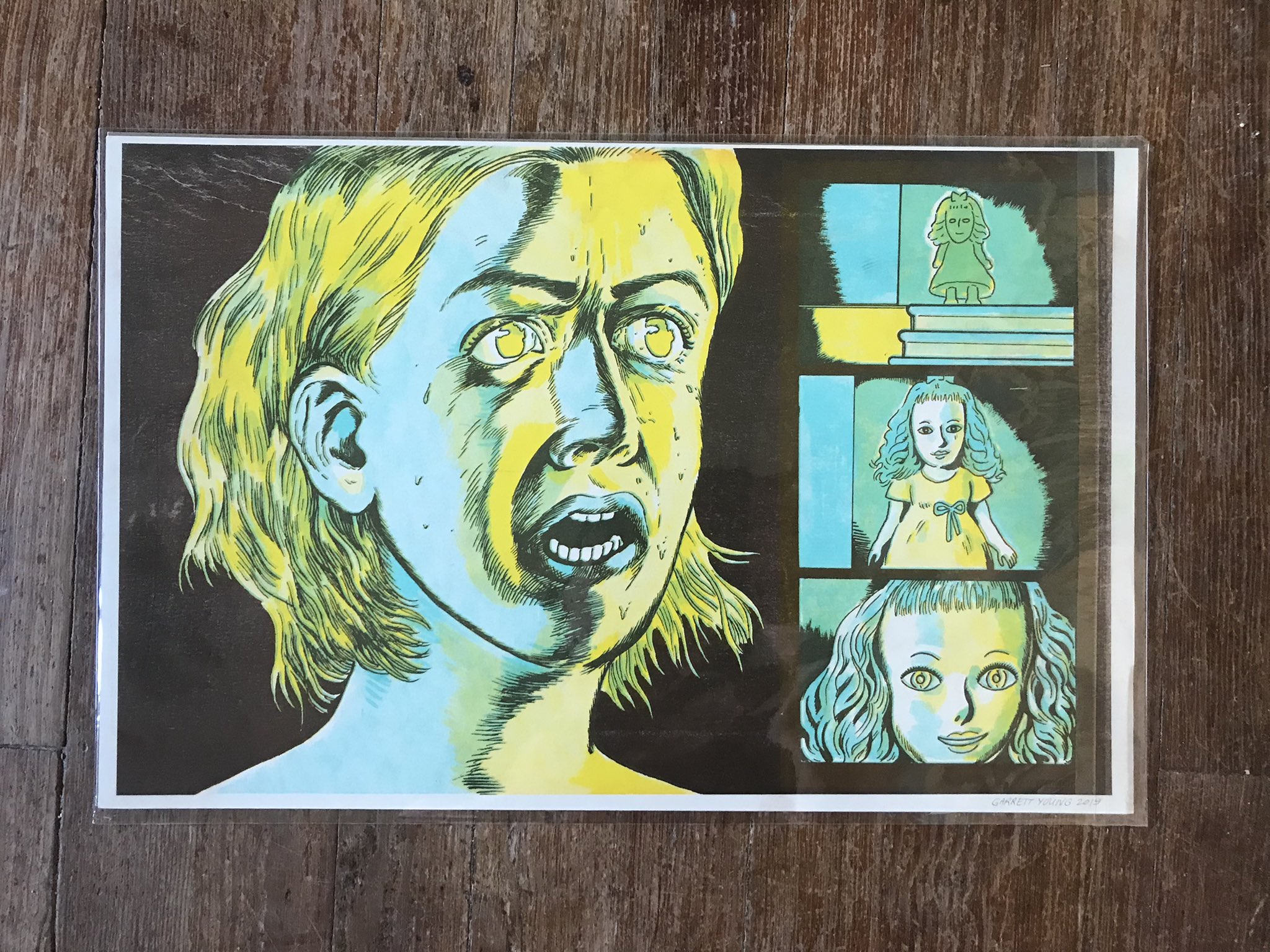 blue and yellow riso print of an illustration of what appears to be a woman screaming in horror at the sight of what appears to be a haunted doll or something  