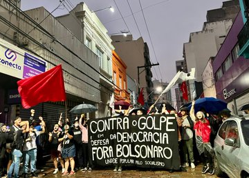 Manifestantes seguram uma faixa em que está escrito: "Contra o golpe e em defesa da democracia, fora Bolsonaro! Unidade popular pelo socialismo"