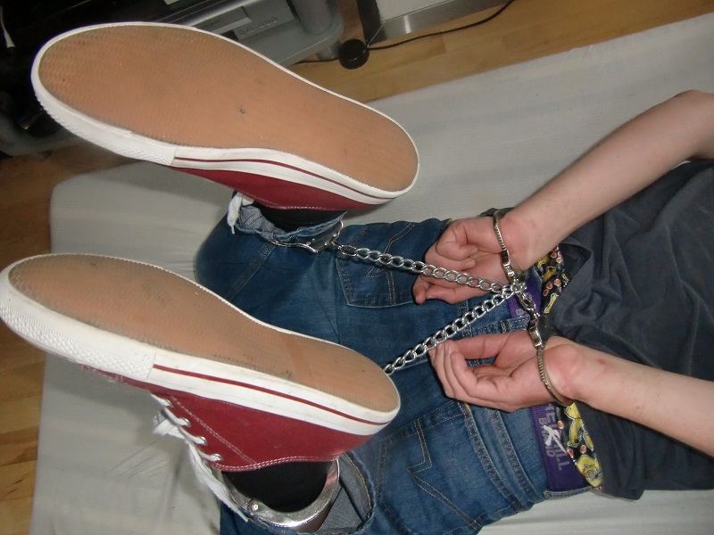 Tim tried to escape but was stopped. He was forced to the floor and his hands were forced behind his back. Handcuffs were tightly put in place, then foot irons that were chained together with the handcuffs in a hogtied. Now he had to face 100% captivity.