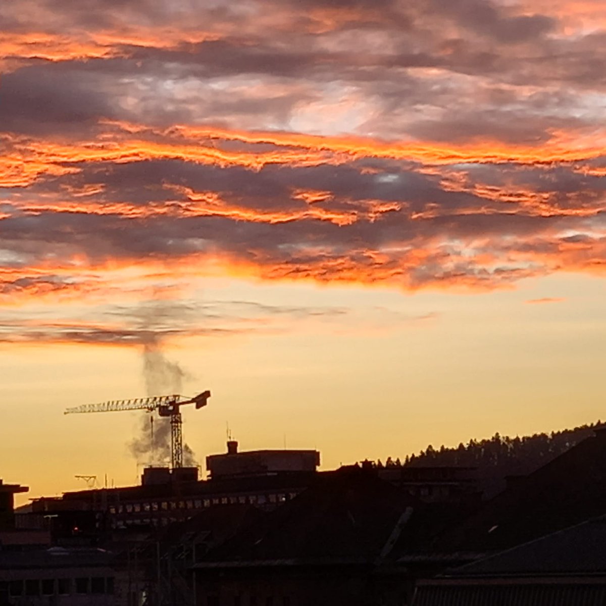 Urban landscape with crane and a fiery burning sky in a winter like no other. Missing the white.