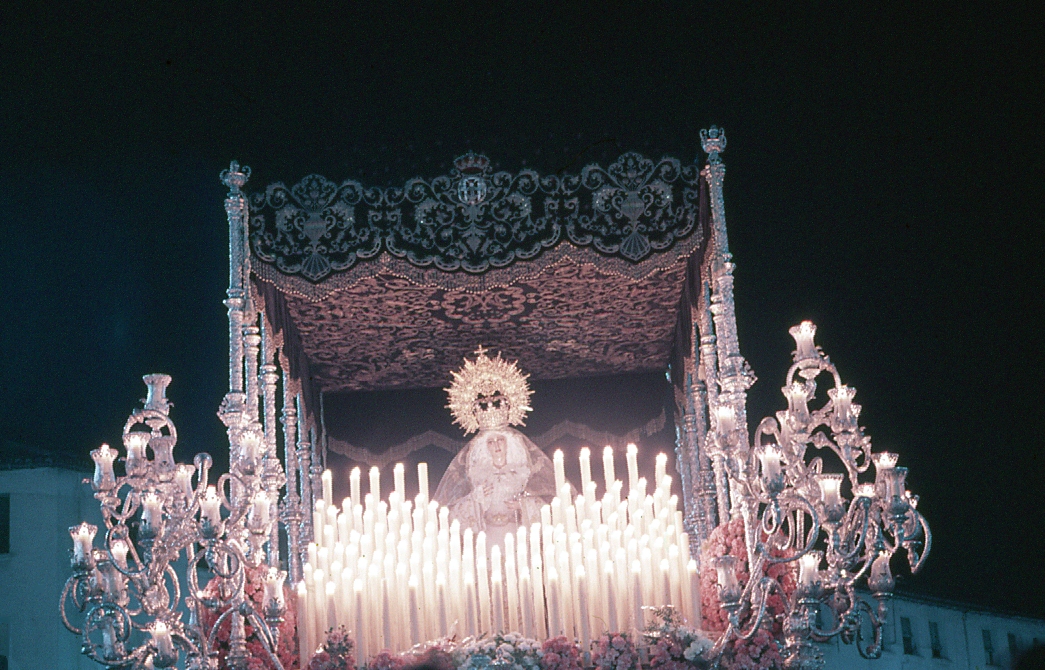 La Virgen de la Paz con la candelería totalmente encendida era un ascua de luz iluminando el Perchel. Diapositiva de 1986. #CofradiasMLG