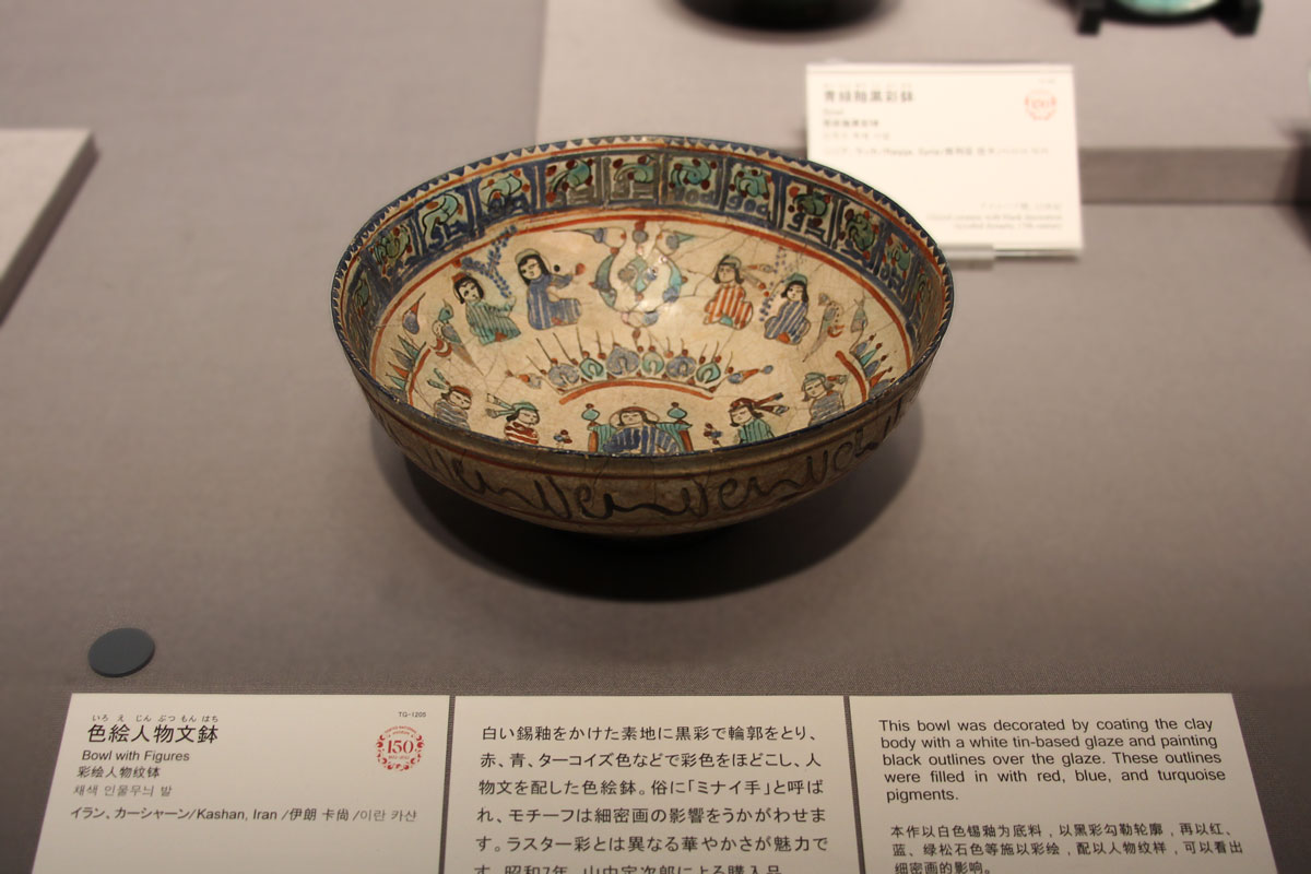 白釉をかけた素地に黒で輪郭をとり、赤、青、ターコイズ色などで人物文