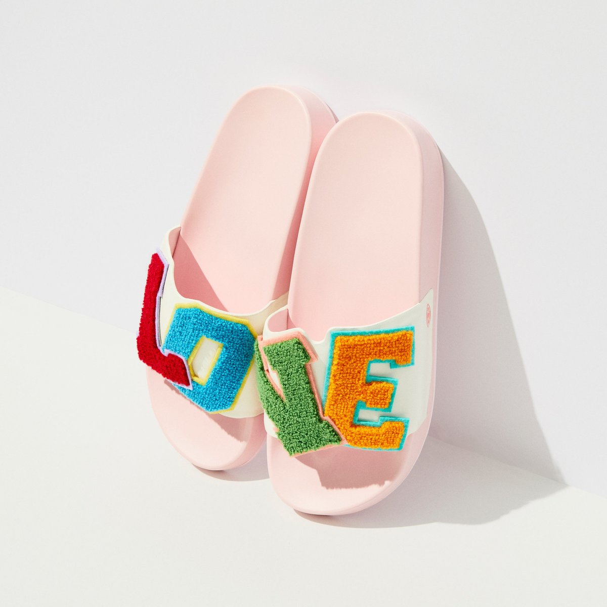 The ultra-comfortable Love Slides are back. Our take on a lightweight slip-on features
a molded EVA sole and leather upper appliquéd with chenille patches. #TorySport #ToryBurch