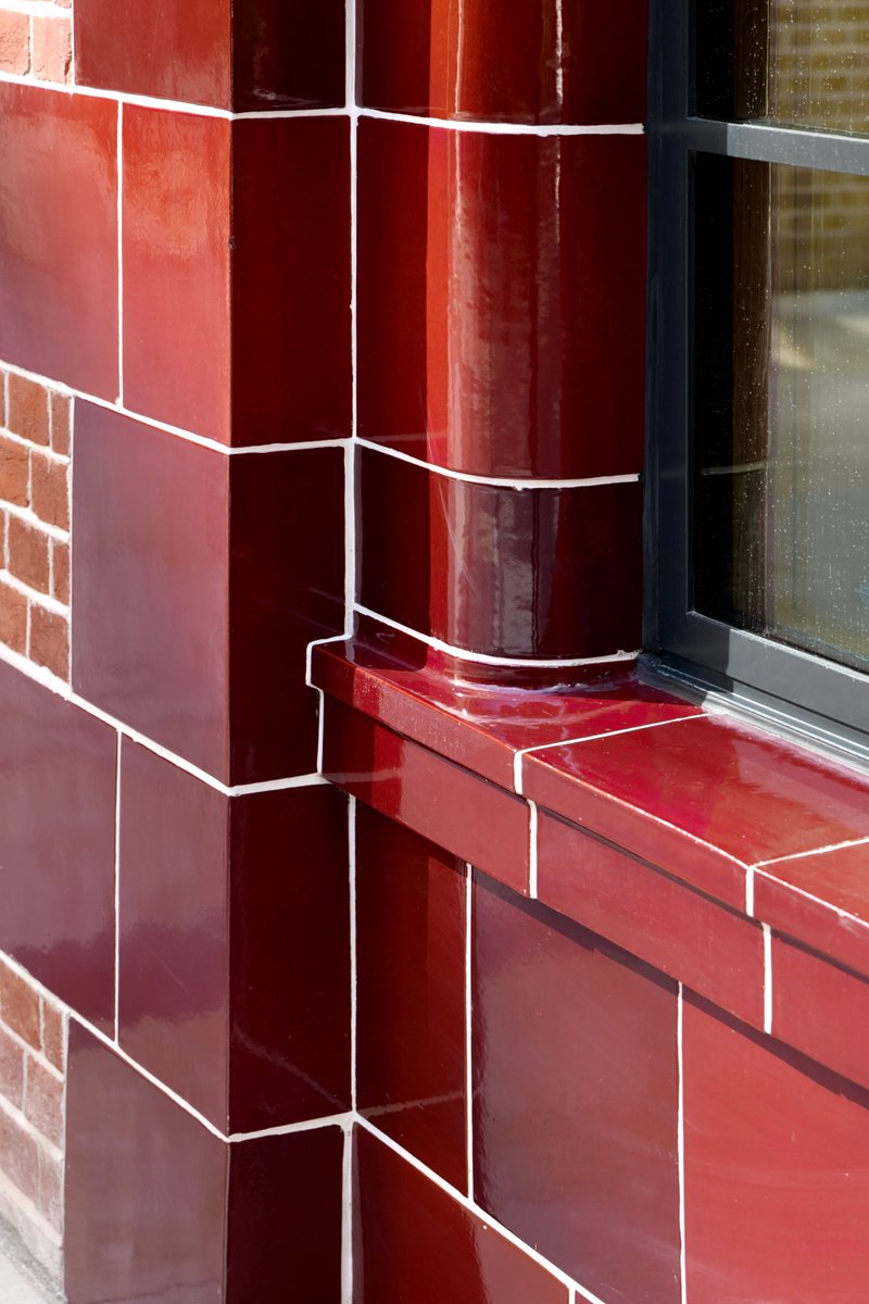 The gleaming façade of One Hooper’s Court includes restored original oxblood tiles, a distinctive architectural feature of many London tube stations.