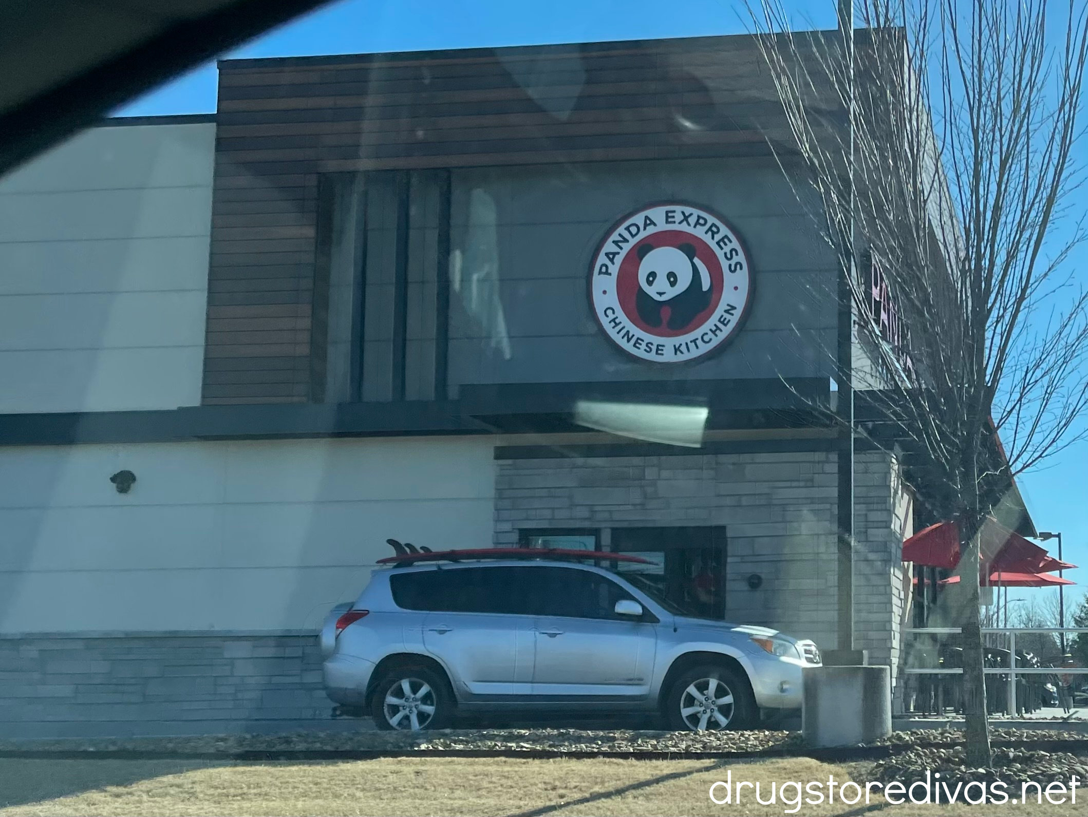 A car at the drive through of a Panda Express restaurant.