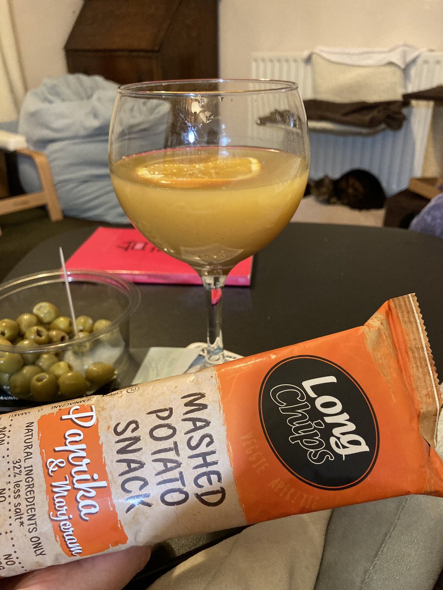 stefarchivist's tweet photo. There was a cold & wet walk back from the bus stop, so I’m starting #ConfinedCocktails early with a Bellini, olives and Eastern European snacks. #bonuscat https://t.co/iQQlD064WD