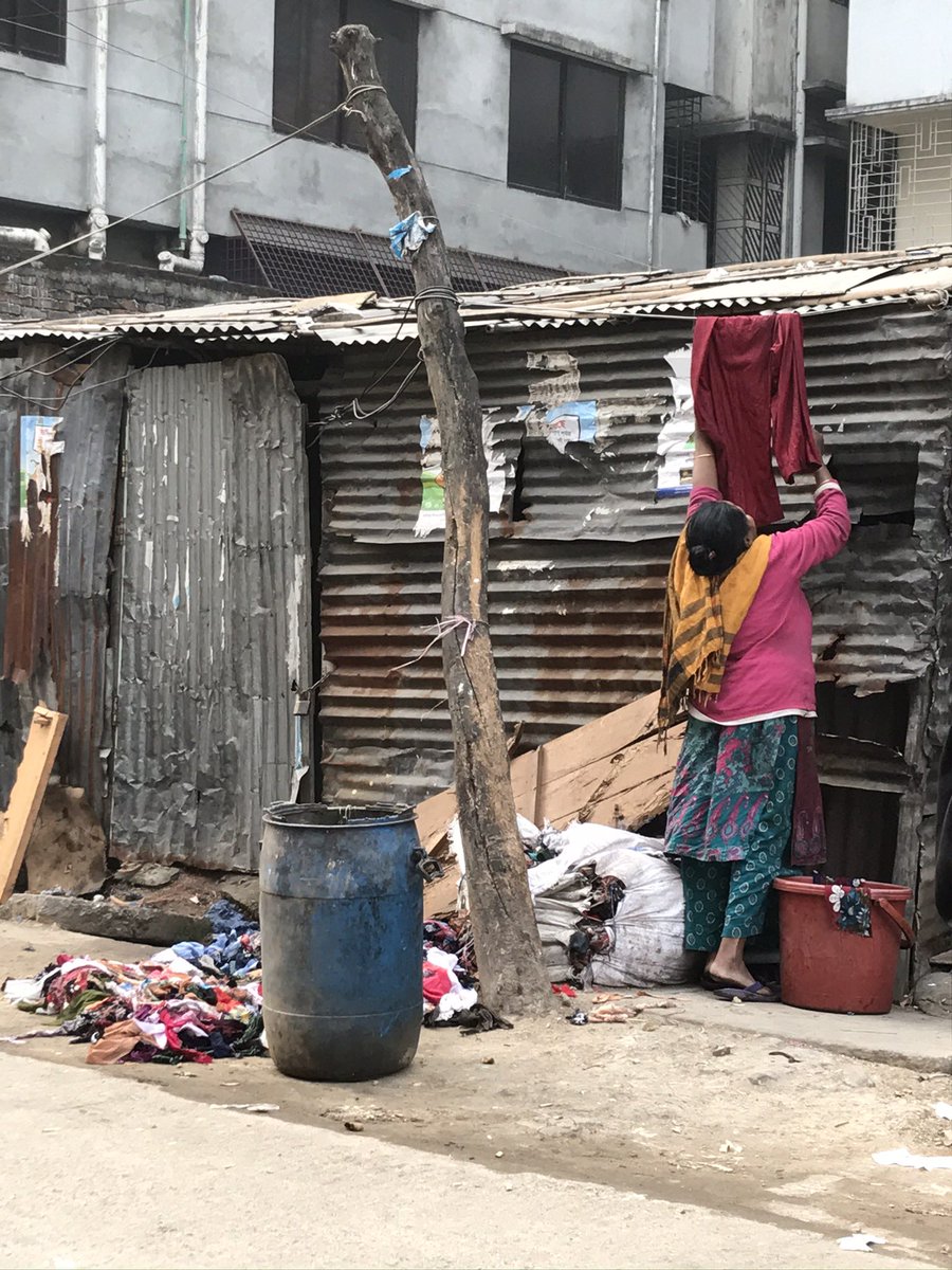 annrunnel's tweet photo. A lady in the morning hanging laundry to dry while the bags of #textilewaste that has been delivered as fuel for the stove for cooking has fell apart next to her. All textile waste has market value in Asia, question is how much of it finds a better use. #textilerecycling https://t.co/noFDfpqA11