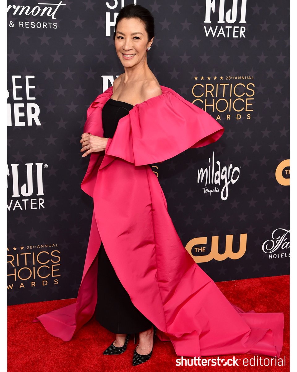 Glamorous! @CriticsChoice nominee #MichelleYeoh wears a chic black gown complete with a hot pink floor-length shawl. #CriticsChoice shutr.bz/3gWwqwr 📸 Stewart Cook/@Shutterstock