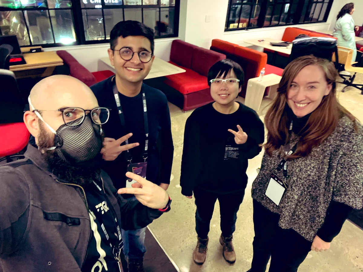 High-angle shot: 4 members of our team at the hackathon, smiling. I’m wearing the new Vive Elite in glasses mode on my head.
