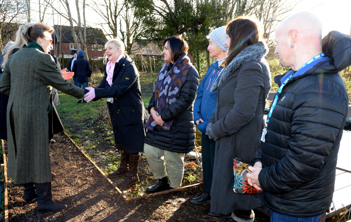 HRH The Princess Royal shakes hand with a person at he allotment