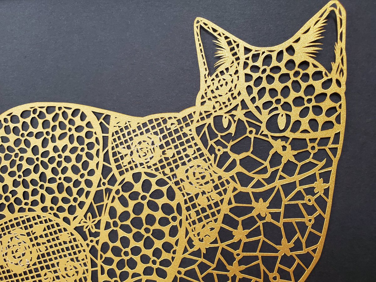 ATkirie's tweet photo. 切り絵新作出来ました
以前からあったデザ���ン(三毛猫がモチーフだったので3種の色紙で切る予定)を金紙1枚で切って蒔絵風に仕上げました。
今週末の譲渡会バザーで販売します
 #NYAWREKA  #ねこといっしょ https://t.co/jadrmBNwNK