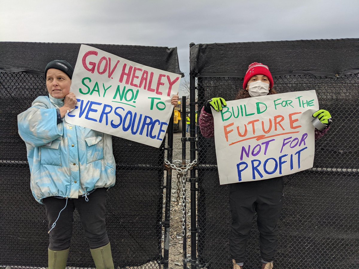 XRBoston's tweet photo. UPDATE: Two peaceful climate activists have been arrested for trying to place two signs on the construction site for a disaster in the making. We are still chanting, we are still singing. #Neversource #NoEastieSubstation https://t.co/aXtl5OSrM6