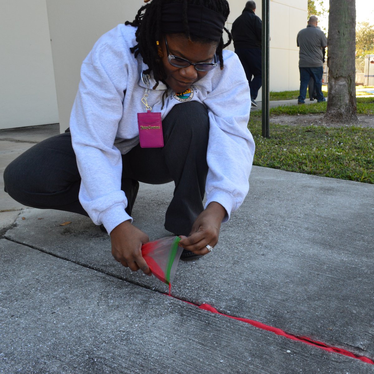 PBCOEM's tweet photo. Our TEAM participated in the #RedSandProject for #HumanTraffickingAwareness. We filled sidewalk cracks outside the Emergency Operations Center with red sand to highlight the ways people are vulnerable to exploitation. #PBSO #PBCVS https://t.co/FXlz1ToCqN