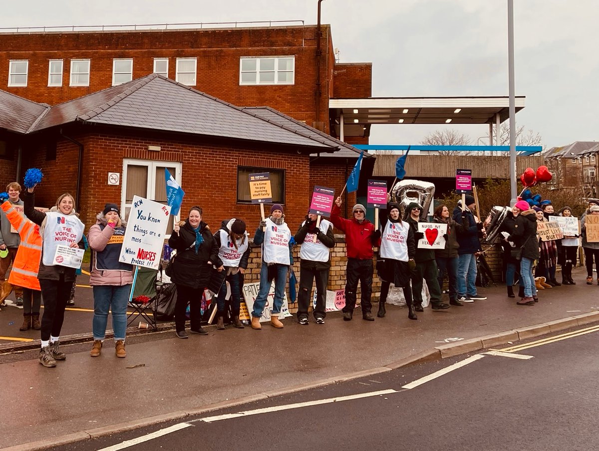 RCNSouthWest's tweet photo. Smiley members at @DorsetHealth Care out protesting on behalf of their patients and all of us. Interesting sum on the maths banner too - can you work out the answer @RishiSunak? #RCNStrike #FairPayForNursing #SafeStaffingSavesLives https://t.co/ySso1E91d0