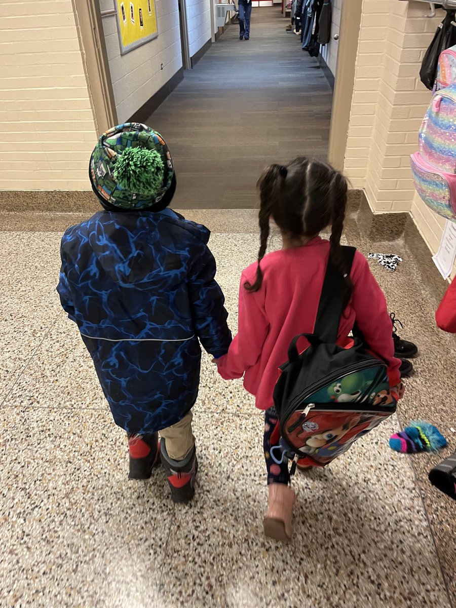 Two kindergarten students headed to the office.  The one on the right carrying the other students backpack for him and making sure he can find the office to leave for an appointment.  #benice #precious #positiveculture #proudprincipal