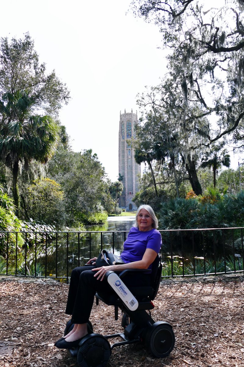 Cheryl enjoys a scenic moment, sitting on her @WHILL_US C2 amidst nature with Bok Tower rising majestically in the background. Visiting Central Florida, you should include @BokTower on your trip.  @VisitCentralFL  #accessibleadventures #boktowergardens