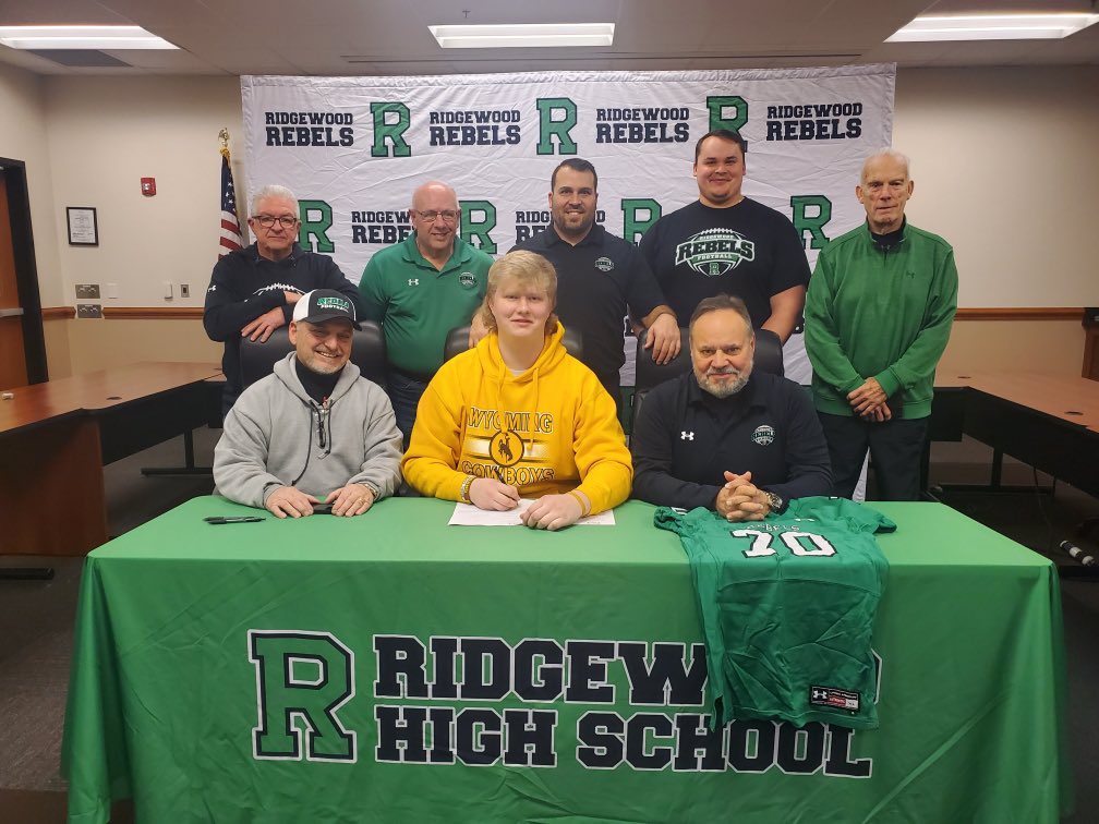 RHSAthletics234's tweet photo. 💚🏈💚 Special moment at RHS this afternoon.  Senior, Kuba Tyszka, makes it official and signs his letter of intent to continue his education and playing career at the University of Wyoming. His proud family, coaches, and friends in support.  Good luck KT!  @RHSRebelPride https://t.co/Bi2kUK02UN