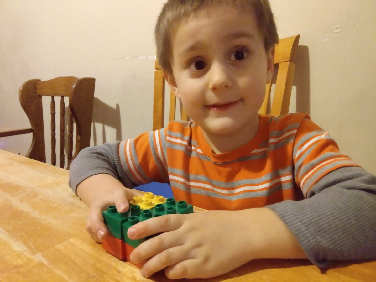 Nathan holding his four stacks of two in a square configuration to make a cube.