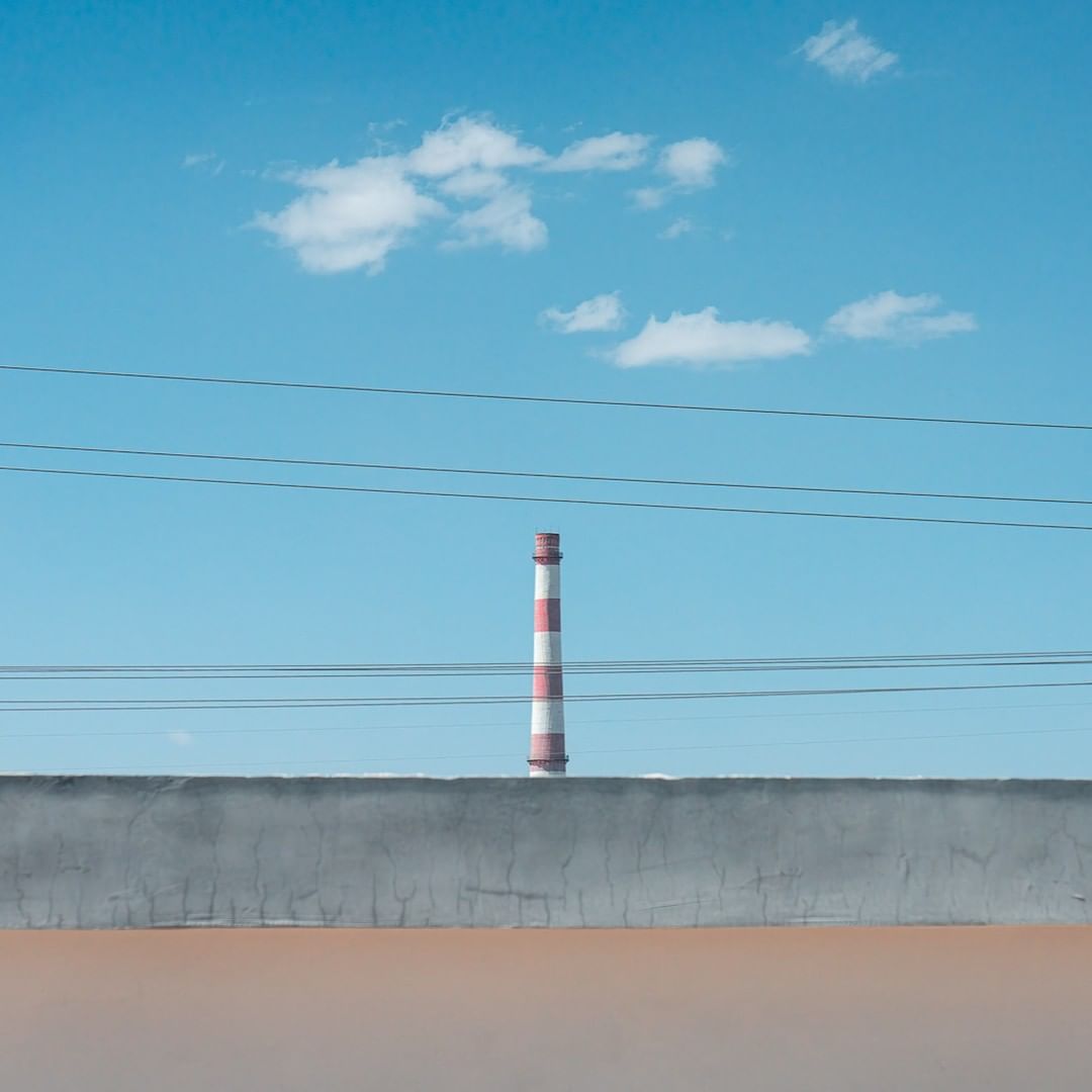 thomaschuphoto's tweet photo. The small station buildings, factories in the distance, electric wires, and blue sky and white clouds all build a unique geometric pattern. #travel #PhotographyIsArt #SkyeBlue #travelblogger https://t.co/FKDjBEM8TY