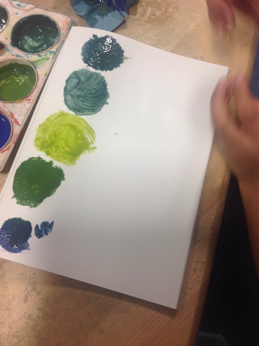 The Year One children in Elm Class are exploring different "hues" of green by mixing primary colours.