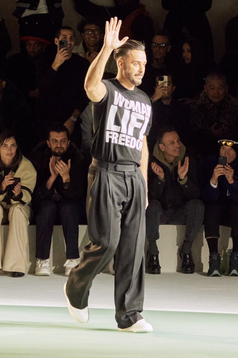 CFDA's tweet photo. Mike Amiri made an important statement during his #PFW runway bow. With his “Woman, Life, Freedom” T-Shirt, the #CFDAmember, who is of Iranian descent, brought attention to and showed his support for the continued fight of all Iranians for basic human rights and change 🙏 https://t.co/u2KDxackYk
