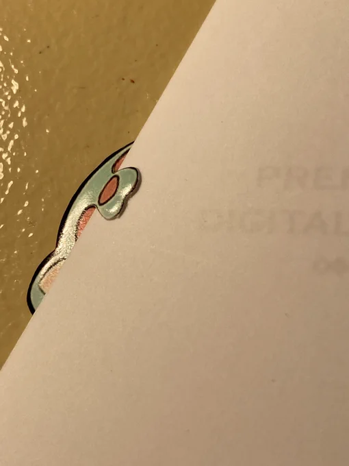 切りずらしをした箇所はそのままだと断面が見えてしまうので、縁塗りをします。がしかし。そのまま塗るとイラストに筆ペンなどのインクが付着してしまう危険があるので、このように紙を挟んでから作業を行うとイラスト面を汚すことなく断面を塗ることが出来ます。マスキングみたいなものですね。 