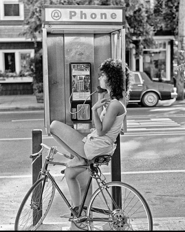 LaocoonofTroy's tweet photo. A young woman, talking on a payphone in the 1980s. https://t.co/yEFbZJ3M0W