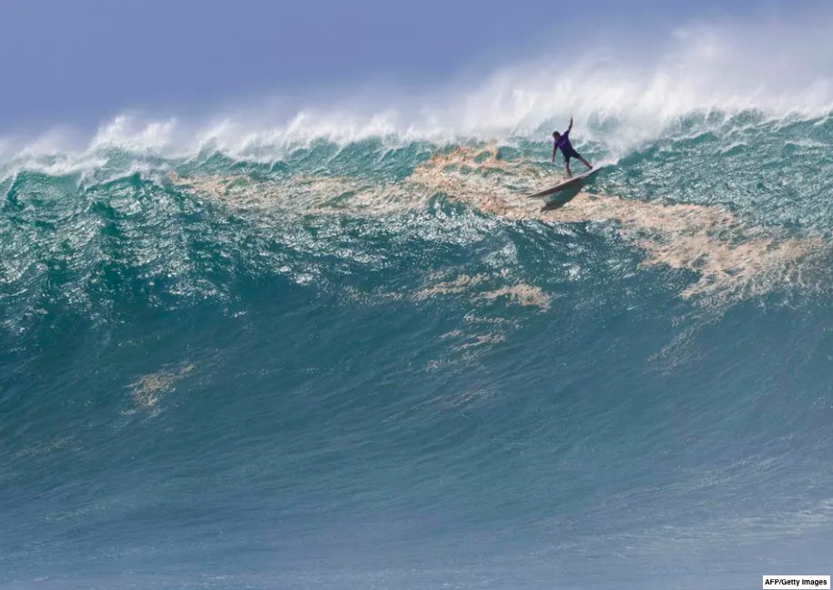 🏄‍♂️👀 Hawaiian surfer Mark Healy rides a wave during the Eddie Aikau Big Wave Invitational surfing contest at Waimea Bay on the North Shore of Oahu in Hawaii. 🌊