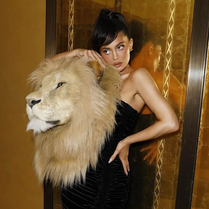 PopBase's tweet photo. PETA approves of Kylie Jenner’s faux lion head at Paris Fashion Week:

“Kylie’s look celebrates lions’ beauty and may be a statement against trophy hunting, in which lion families are torn apart to satisfy human egotism.” https://t.co/fO9eDqBfoM