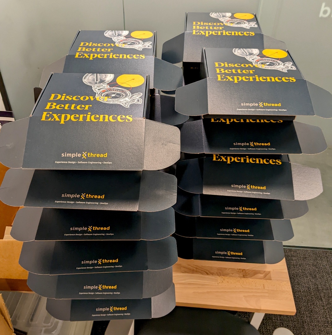 simple_thread's tweet image. Our team had a swagtastic coworking day! They were greeted with #SimpleThread boxes full of t-shirts, hats, coasters, stickers, a bookmark, and other fun items.