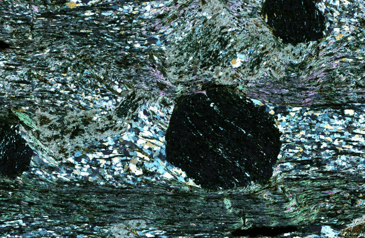 We can't resist sharing one of our favorite examples of schistosity and rotated poikiloblasts for this week's #ThinSectionThursday! Look at that mica-wrapped garnet!