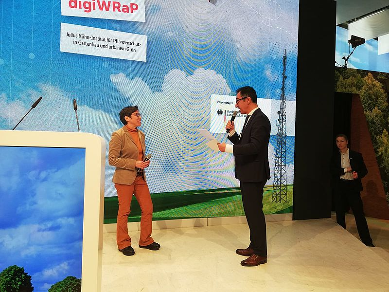 JKI_Bund's tweet photo. Rattenprävention mit ministeriellem Segen. Auf der #IGW2023 überreichte Minister @cem_oezdemir soeben an Dr. Alexandra Esther den Förderbescheid für #DigiWRap. In dem Projekt geht es um die digital gestützte giftfreie Bekämpfung von Ratten. Mehr dazu hier: https://t.co/FUuTH0sblt https://t.co/mzoRUkHF7Q