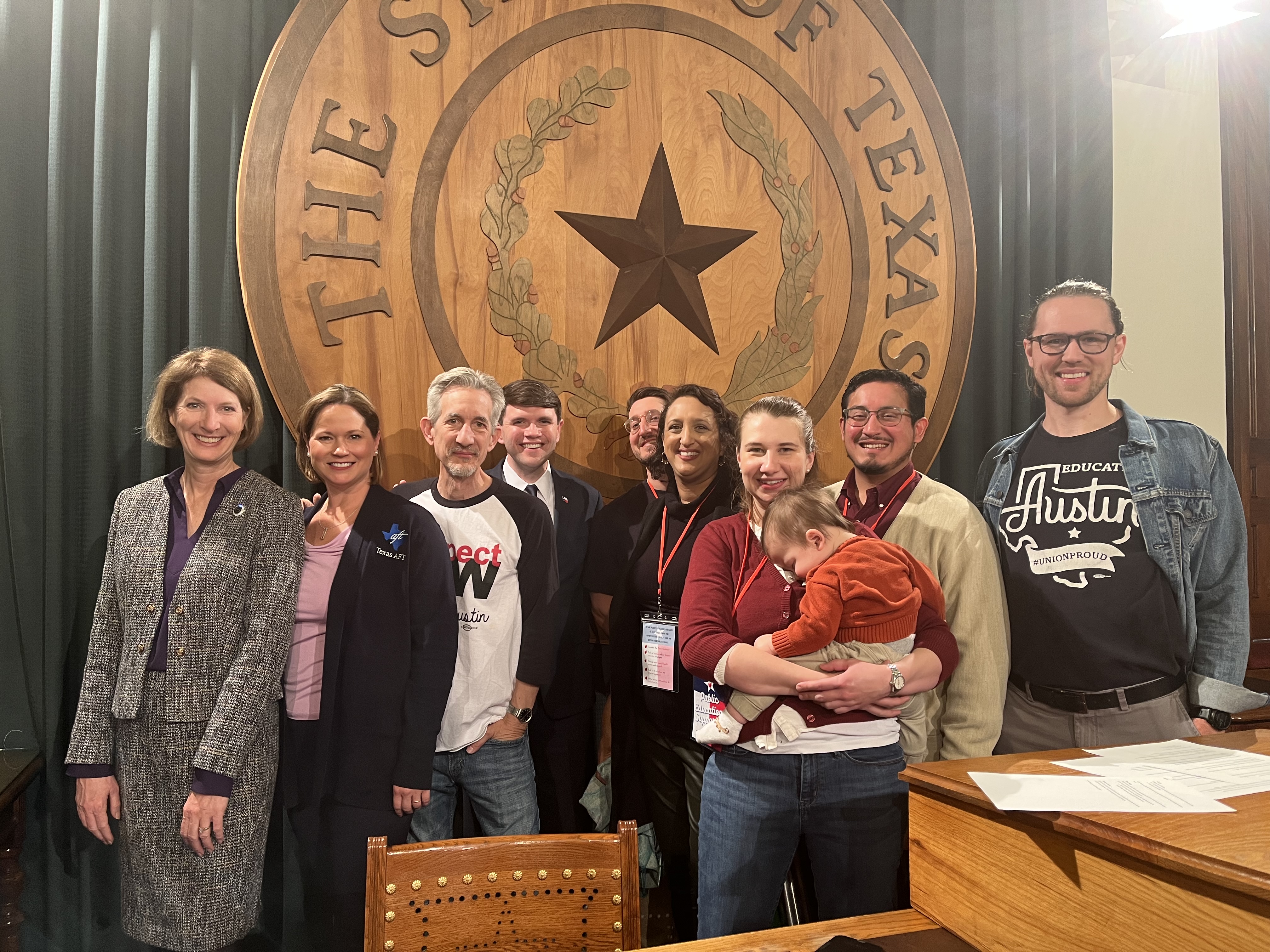 Image of public school advocates posing in front of Seal of Texas