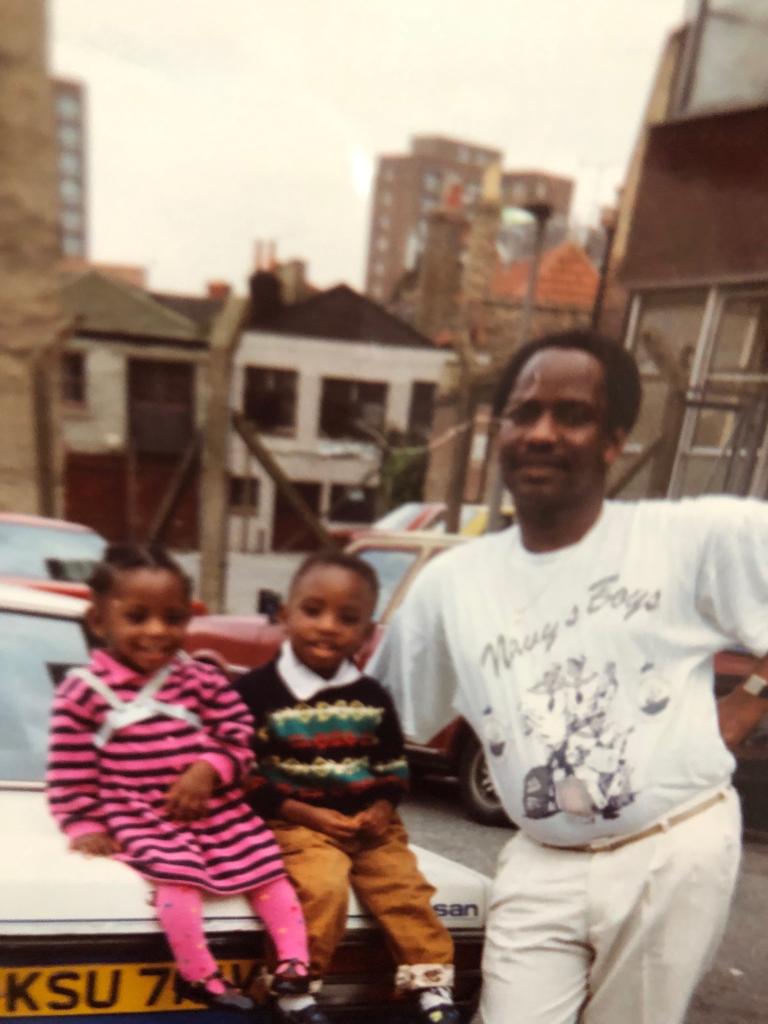 My Dad, brother and sister in the car park behind McDonalds in Dalston, Hackney, with Trelawney Estate in the background. 

This photograph was taken just before I was born in 1991.