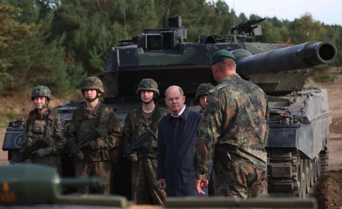 German Chancellor Olaf Scholz (C) talking with soldiers in front of a Leopard 2 main battle tank CREDIT: RONNY HARTMANN/AFP
