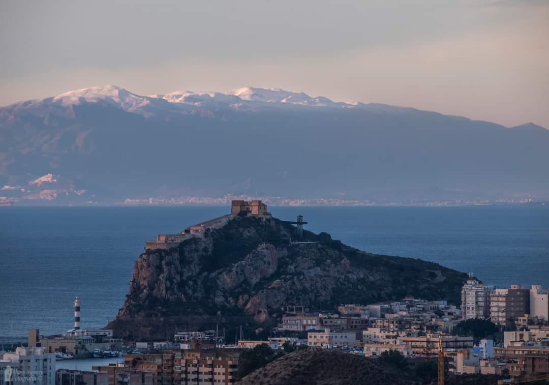 Mario17N's tweet photo. Primer plano del castillo y faro de Águilas al fondo sierra Cabrera(Mojácar y Turre) con sus cimas nevadas. 25-1-23 https://t.co/5oLgASKvWH