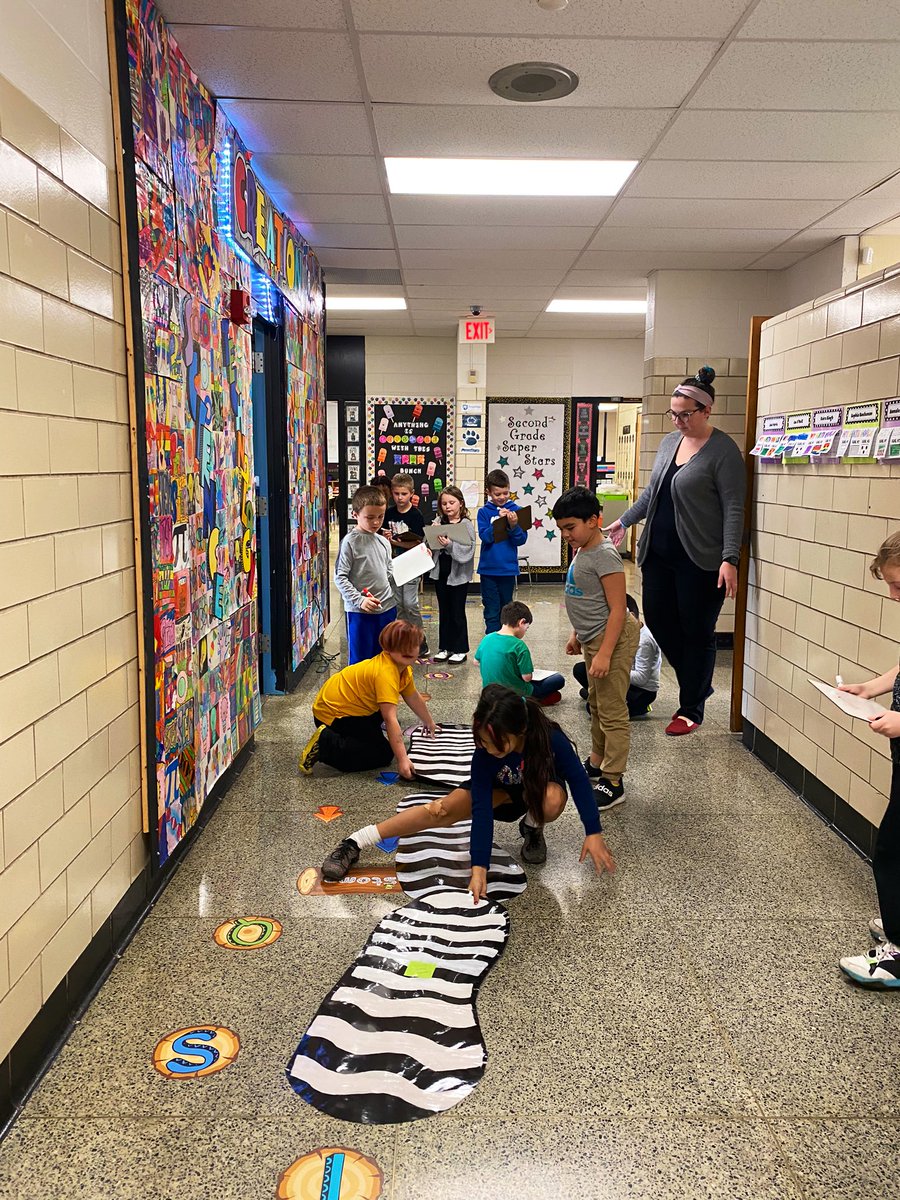ISDmathcoaches's tweet image. Mrs. Price’s second graders estimating and measuring in “Giant’s Feet”.  How many would it take to get from their classroom to the office door? 🤔 There was quite a lot of changing their estimates along the way 😉 @TinicumSchool @ISD_Curriculum