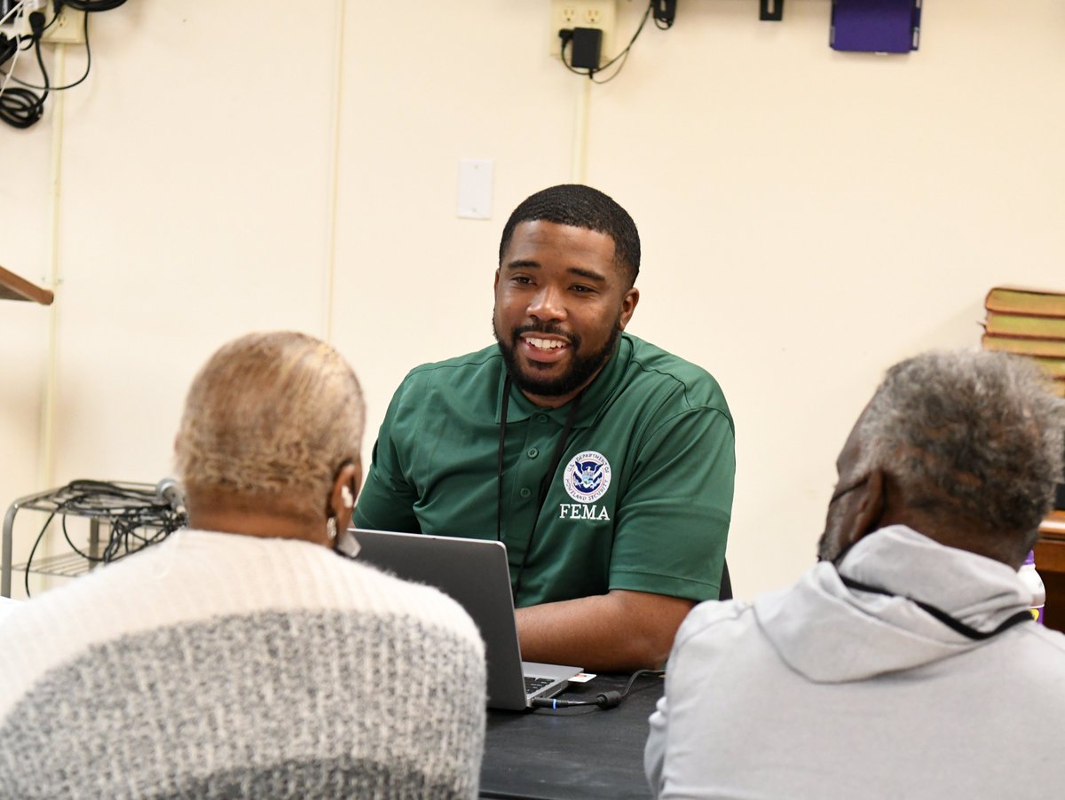 FEMA specialist sits across from two survivors. 