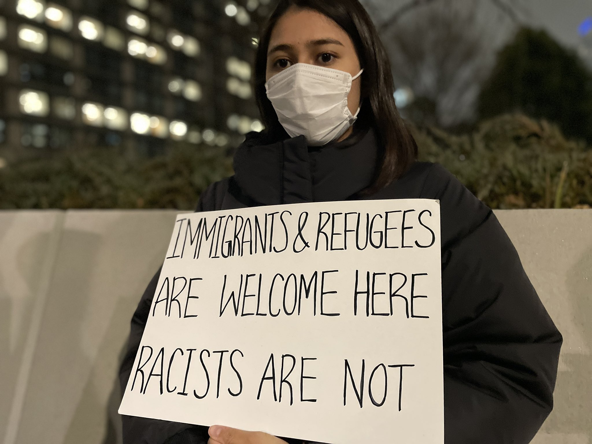 プラカードをもった女性
Immigpants & refugees are welcome here 
Racists are not