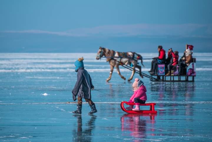 Yüzeyinin büyük bölümü donan Çıldır Gölü'ne aileleriyle gelen çocuklar, atlı kızaklara binerek yarıyıl tatilinin keyfini çıkartıyor
