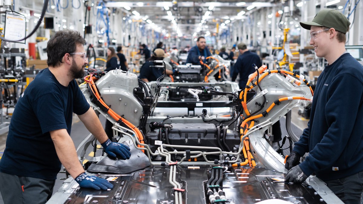 Rivian's tweet photo. We recently added a second shift at our plant, which means we can build vehicles around the clock and continue to ramp production. Follow the link to experience life on the night shift through the eyes of Junior, a team member in General Assembly: https://t.co/EntpsDX7mf https://t.co/B2ih4qe1Uf