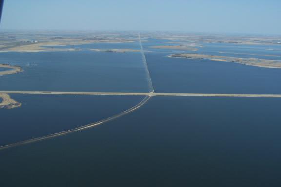 Devils Lake Flooding- From the early 90s to 2011, DL rose 31ft, an increase of 167,070 inundated acres, or about 261 sq miles. Millions of trees submerged, hundreds of homes gone, flooded farms and farmland, over $3B in road restructuring. A man-made dike protects the city