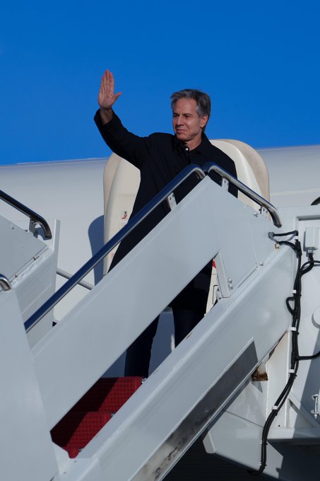 Secretary of State Antony Blinken waves on top of the steps about to board his plane for his trip to Egypt, Israel, and the West Bank.