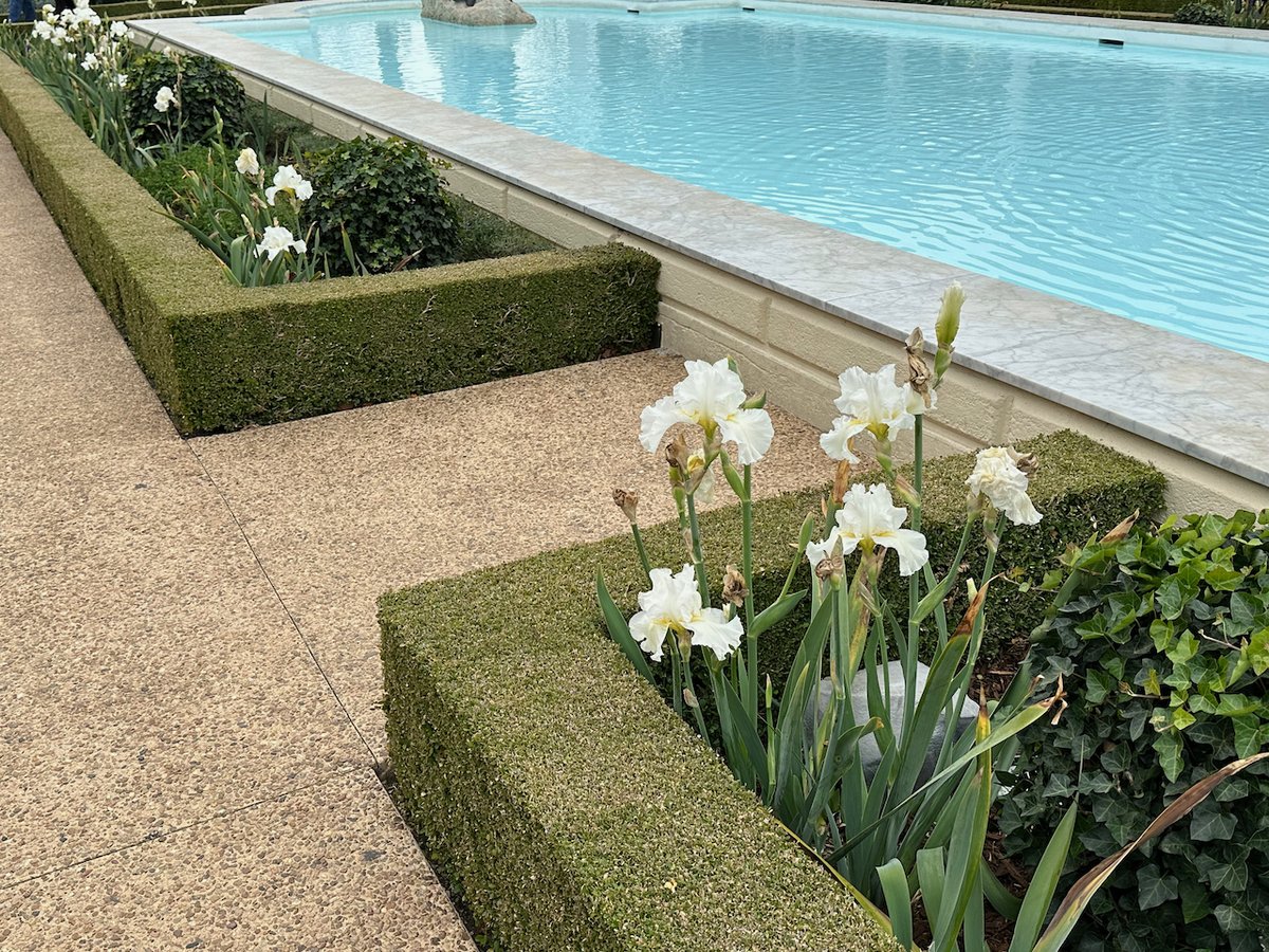 Formal does not have to mean boring or stuffy. Traditional designs can have beautiful flowers and some texture mixed in. #LandscapeStyles #TravelingGardener