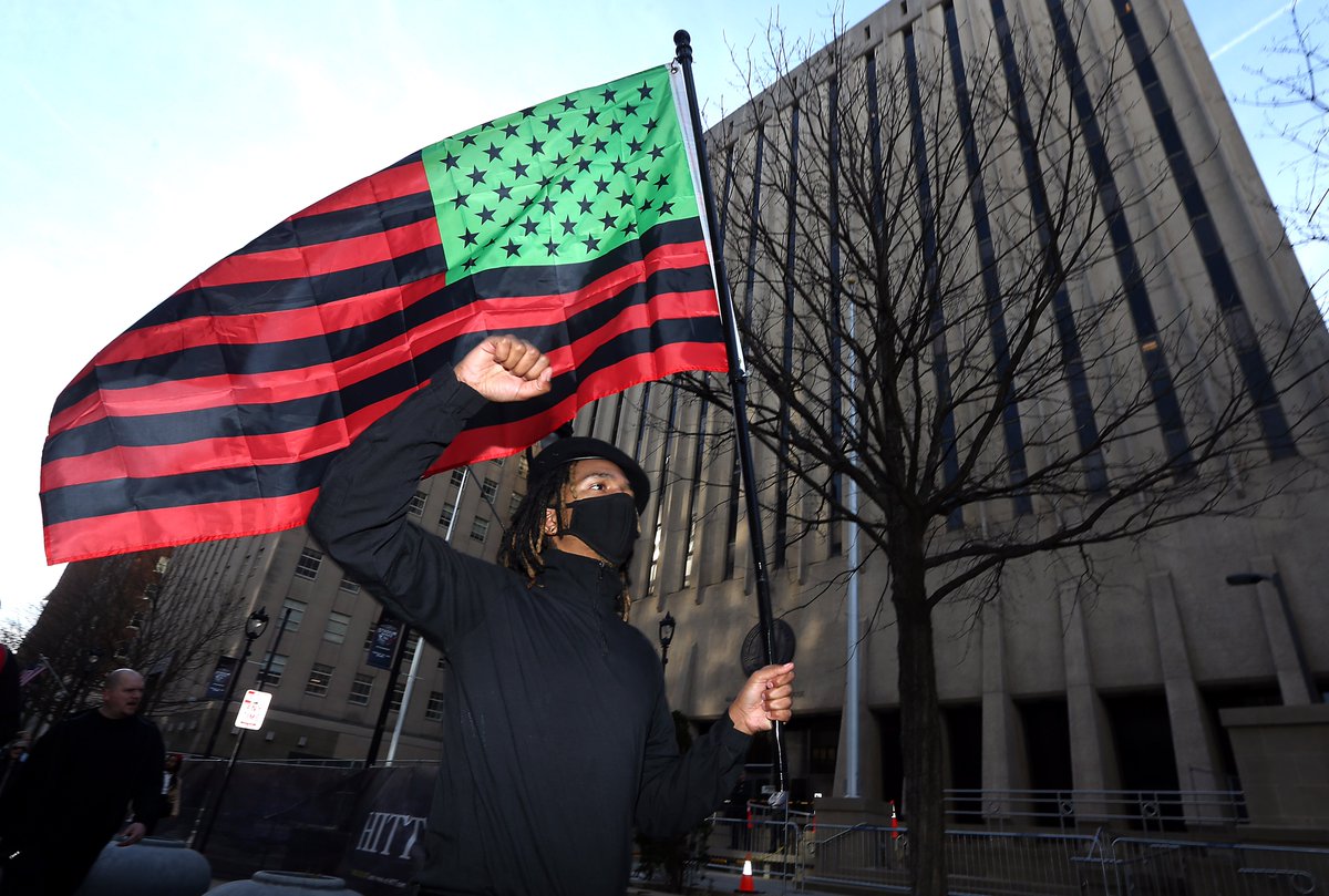 BobKarpDR's tweet photo. Protester walks past the Wake County Courthouse holding Pan-African flag during march in memory of Tyre Nichols and Raleigh’s own Darryl Williams. #AppallingInjustice https://t.co/JzkO8k6Vhw