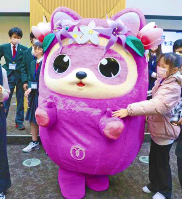 Mizuhomaru, the new mascot for Mizuho (a town in Tokyo), is mix of a Daruma (traditional lucky doll) and a tanuki (raccoon dog). Mizuhomaru is  purple and pink like local flowers (a crown of which are on its head). 